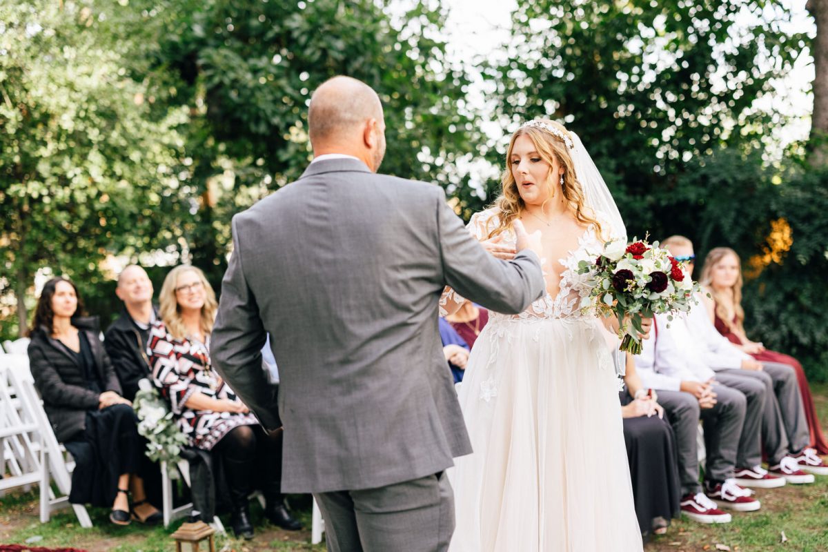secret handshake between bride and her father as he gives her away
