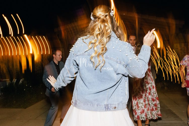 bride dancing at hidden oaks retreat wedding jean jacket