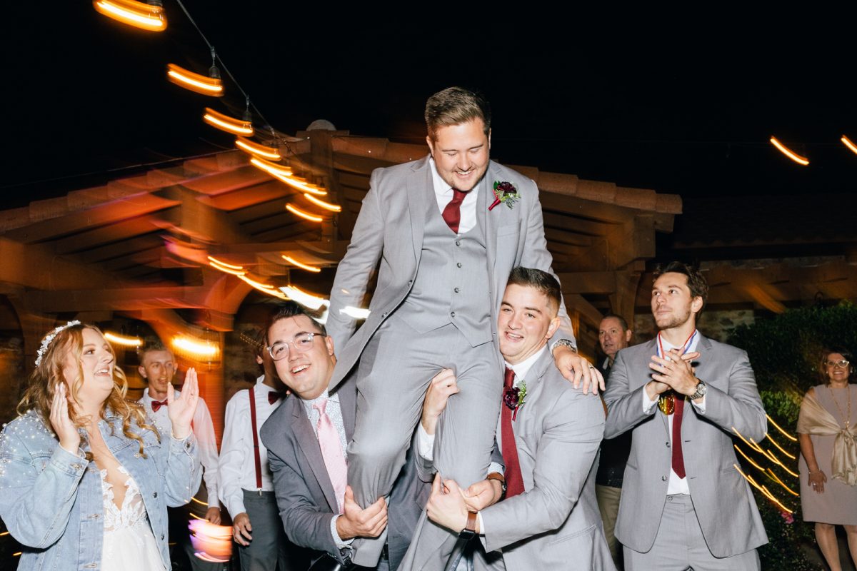 guests picking up groom at wedding reception