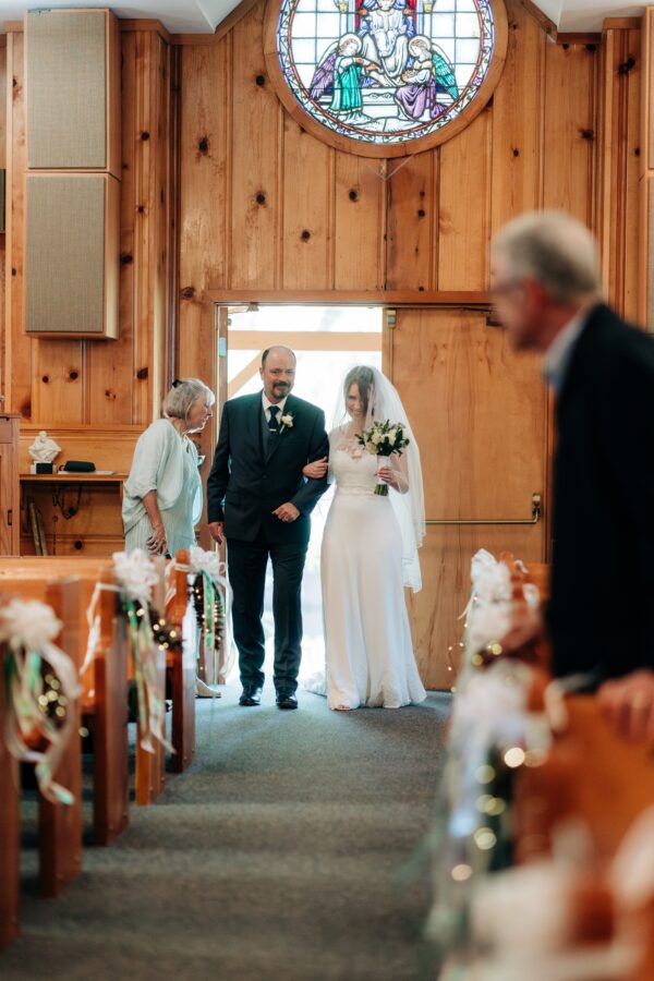 Bride walking up the aisle at queen of angels church