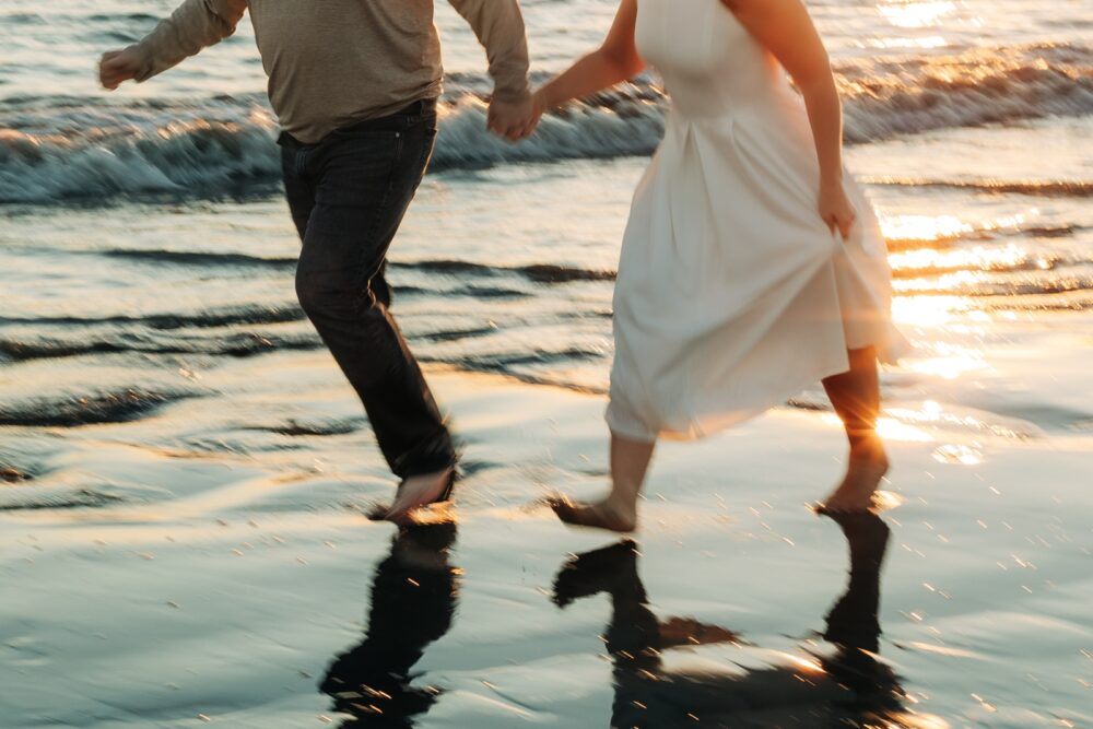 Running on the beach at winter engagement