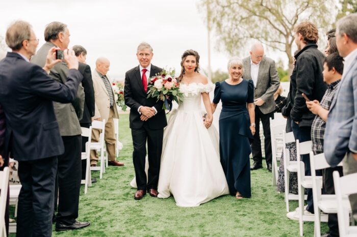 Black and gold spring wedding bride walking up aisle