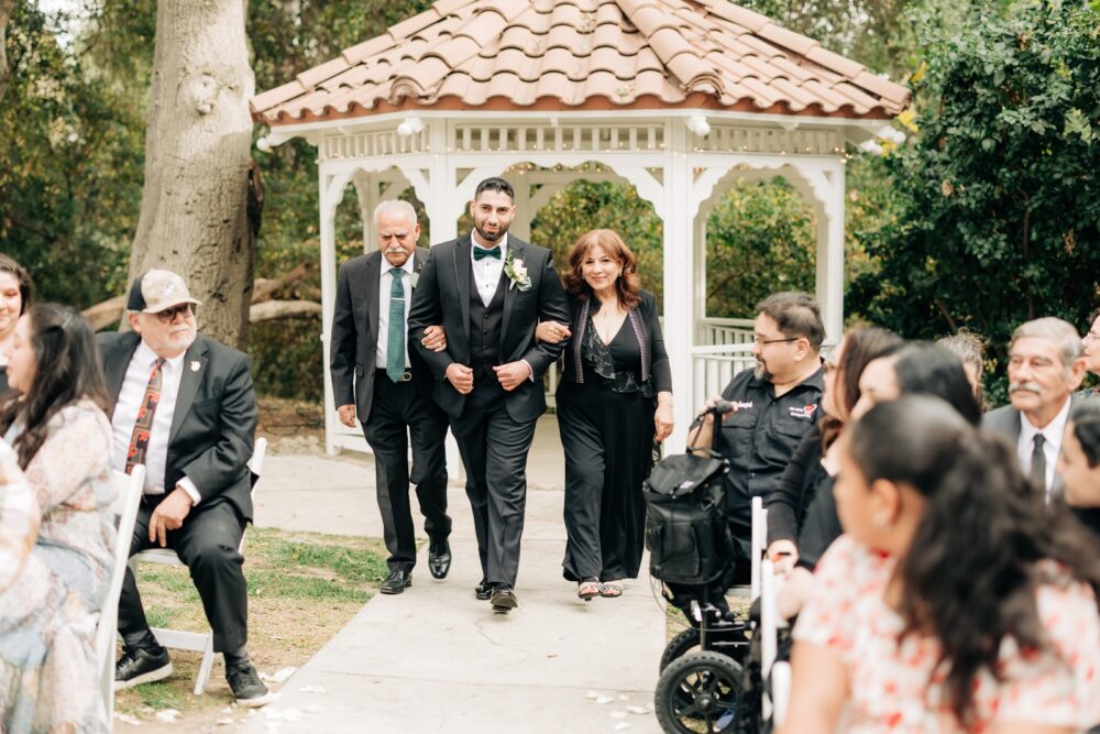 Groom walking up aisle with parents
